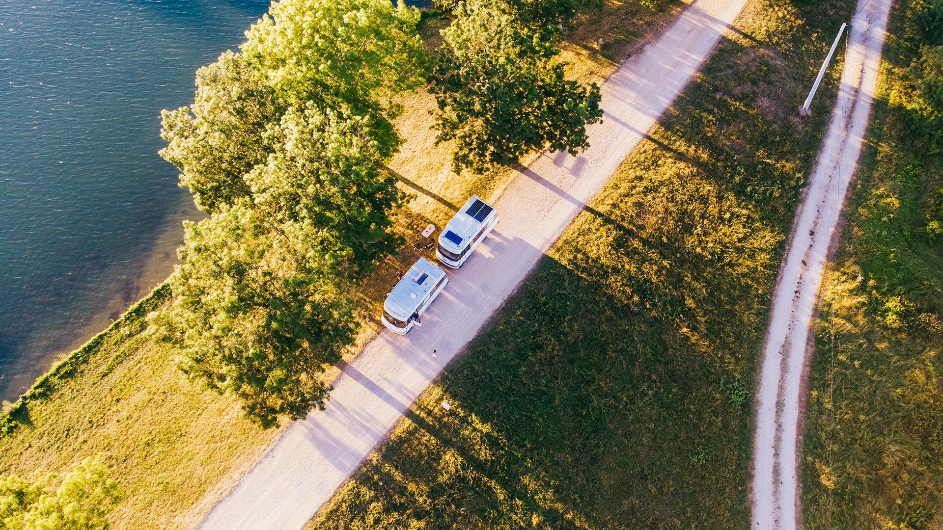 Caravan solar system setup for off-grid travel beside a lakeside campsite